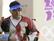 Gagan Narang adjusts his rifle as he prepares to switch from prone to standing position, during qualifiers for the men`s 50-meter rifle 3 positions, at the 2012 Summer Olympics.