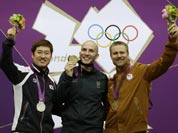 Gold medal winner Italy`s Niccolo Campriani, center, poses for a picture with silver medalist Kim Jonghyun of South Korea, left, and bronze medalist Matthew Emmons of the United States of America, during the victory ceremony for the men`s 50-meter rifle 3 positions event, at the 2012 Summer Olympics