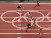 Runners clear a hurdle during round 1 of the women`s 100-meter hurdles during the athletics in the Olympic Stadium at the 2012 Summer Olympics.
