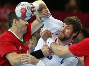 Serbia`s Momir Rnic, right, is tackled by Hungary`s Ferenc Ilyes, left, during their men`s handball preliminary match at the 2012 Summer Olympics in London