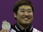 South Korea`s Kim Jonghyun holds up his silver medal, during the victory ceremony for the men`s 50-meter rifle 3 positions event, at the 2012 Summer Olympics.